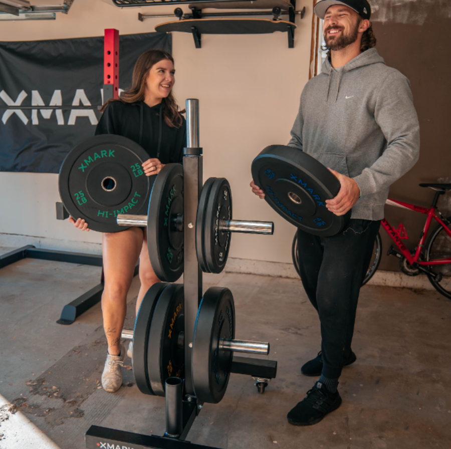 Couple holding bumper plates and laughing