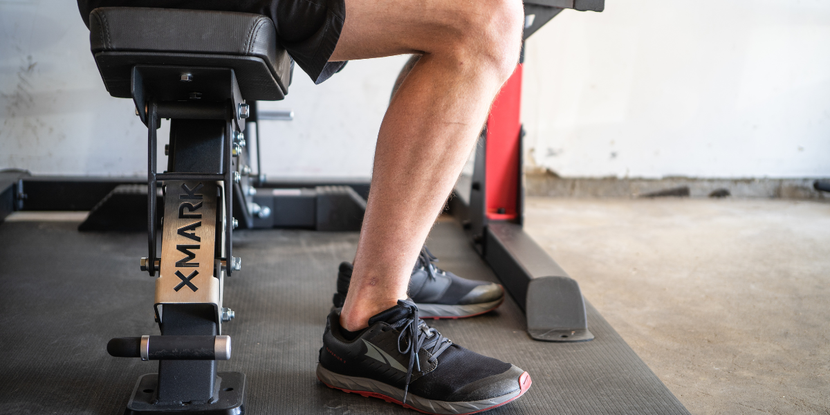 Man sitting on XMARK Black Hawk Adjustable Bench 