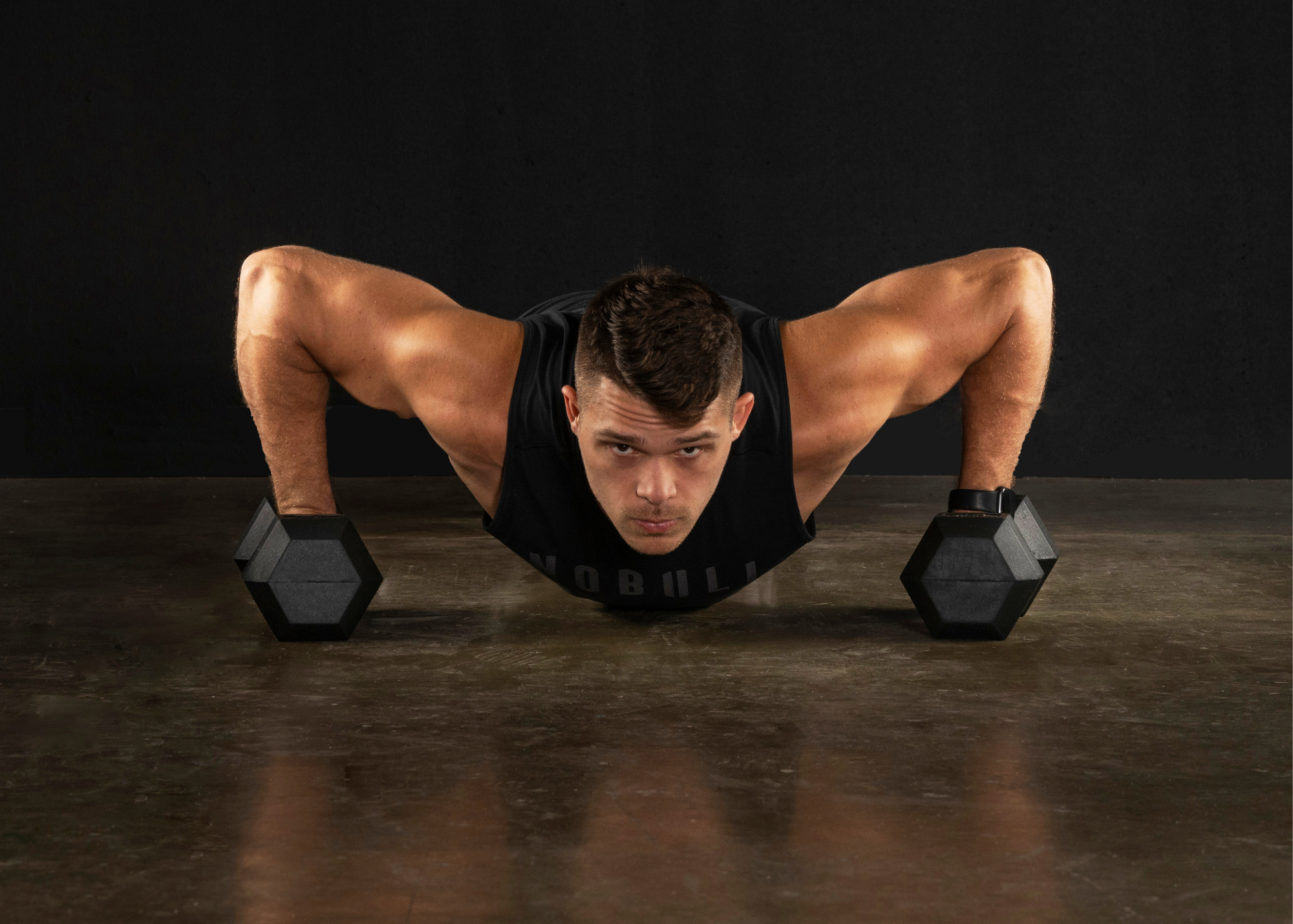 Male doing plank with hex dumbbells to add more intensity to the workout.