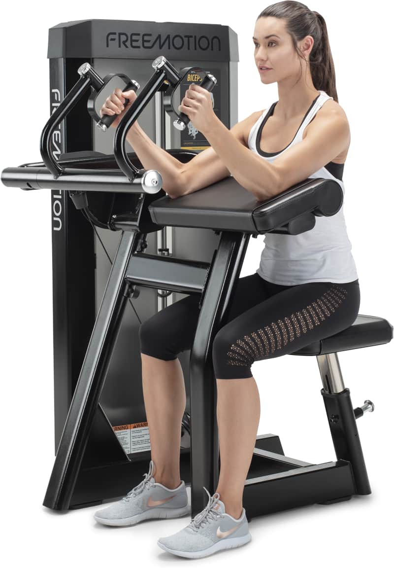A woman exercising on a Freemotion biceps curl machine, side view