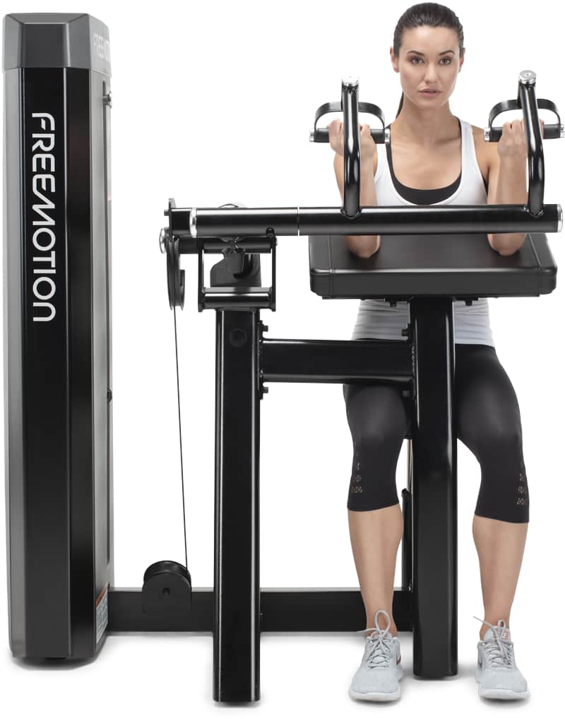 A woman exercising on a Freemotion biceps curl machine
