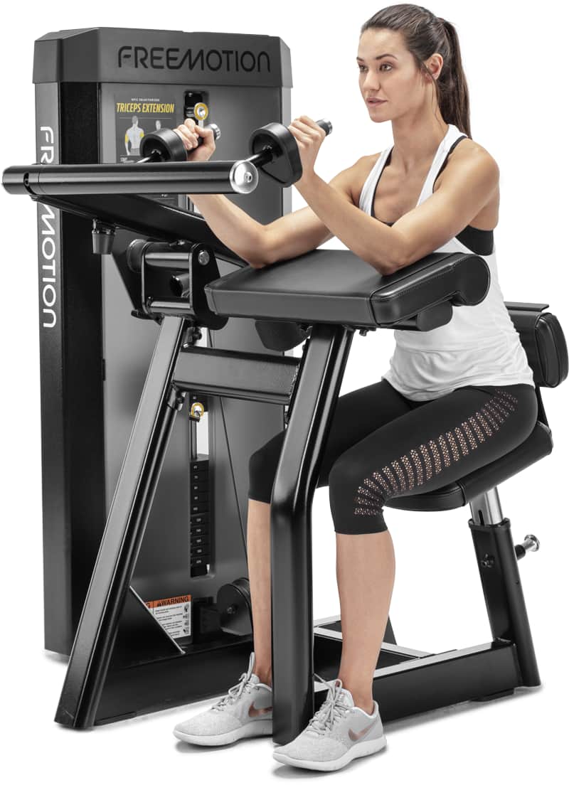 A woman exercising on a Freemotion selectorized triceps extension machine