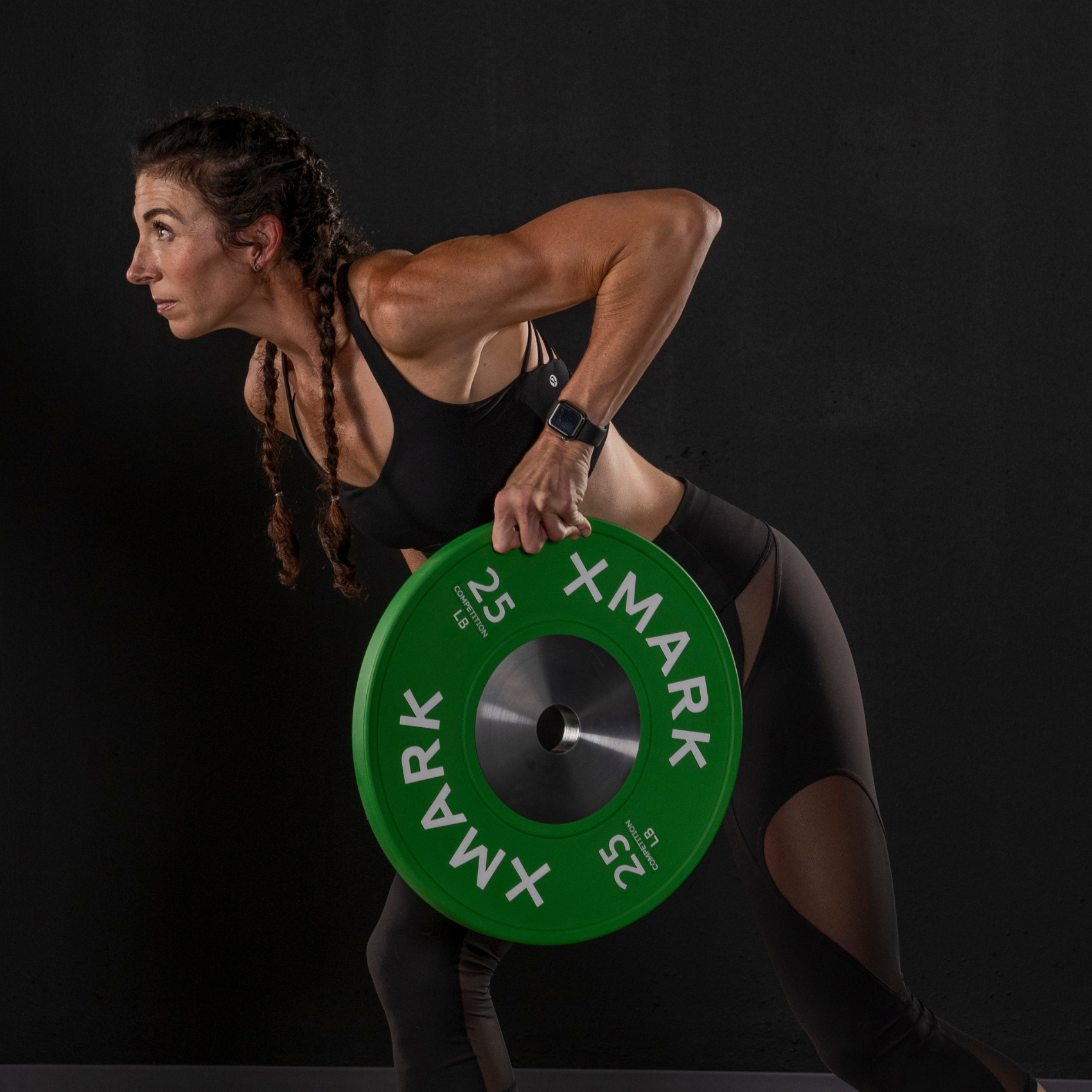 WOMAN DOING A ROW WITH AN XMARK BUMPER PLATE 